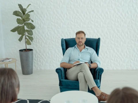 Counselor sitting in an armchair during a session
